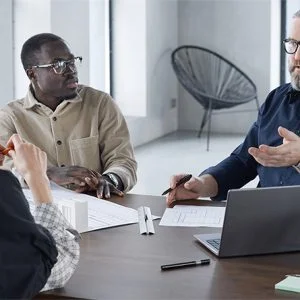 Gestores e colaboradores em reunião estratégica analisando gráficos